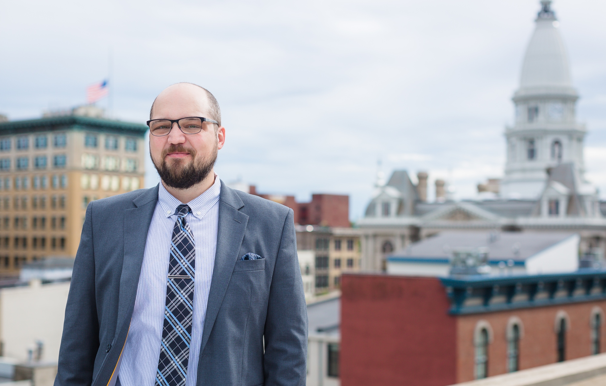 Stuart & Branigin civil litigation attorney Matthew M. Humble candid rooftop with capital in the background.